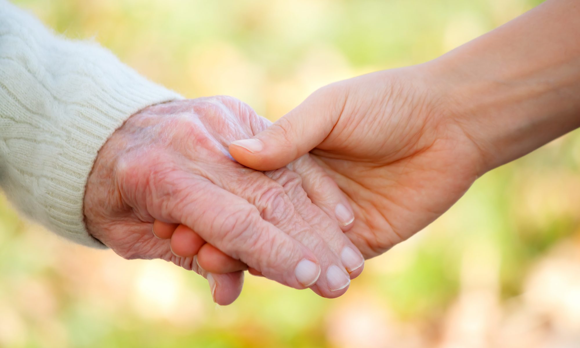 Senior and young holding hands